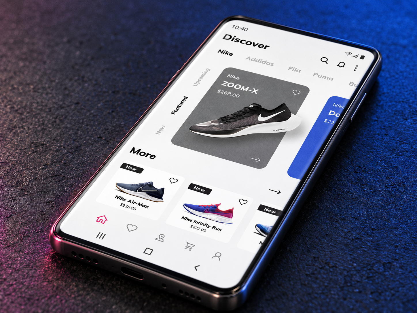 A phone on a dark surface showing the sneaker app's Discover screen with product cards.